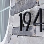 Black 194 numbering on stone veneer with a round white window